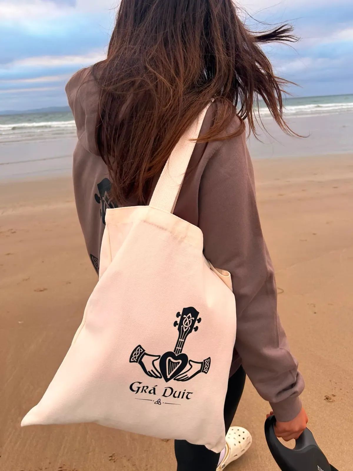 Geansaí agus mála ar an trá